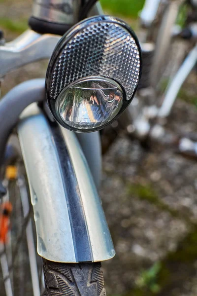 Macro shot of details of a bike with the headlight in focus.