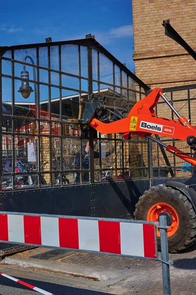 Berlin, Almanya - 9 Nisan 2020: Dresden demiryolu hattında inşaat alanı. Eski bir cam bisiklet kulübesini söken işçilere destek veren bir kazıcı görüyorsunuz..