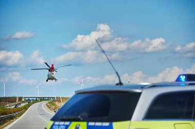 20. Otoyol, Almanya - 30 Ağustos 2020: Almanya 'da bir otoyol kurtarma operasyonu sırasında polis arabası ve helikopteri.