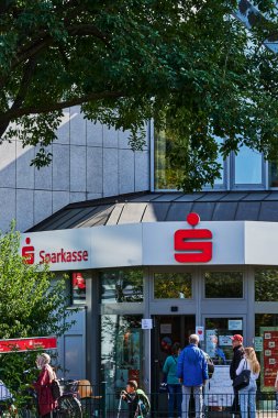 Berlin, Almanya - 17 Eylül 2020: Bazıları Covid-19 yüzünden yüz maskesi takan bir banka şubesinin önünde kuyruğa giren müşteriler.