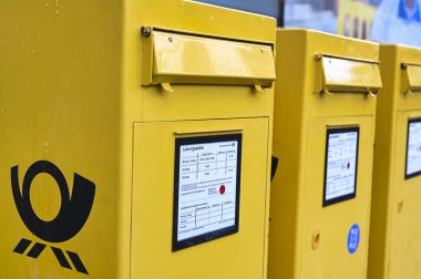 Berlin, Almanya - 5 Ekim 2019: Berlin, Almanya 'da kaldırımda üzerinde Alman Posta logosu bulunan çeşitli posta kutuları.