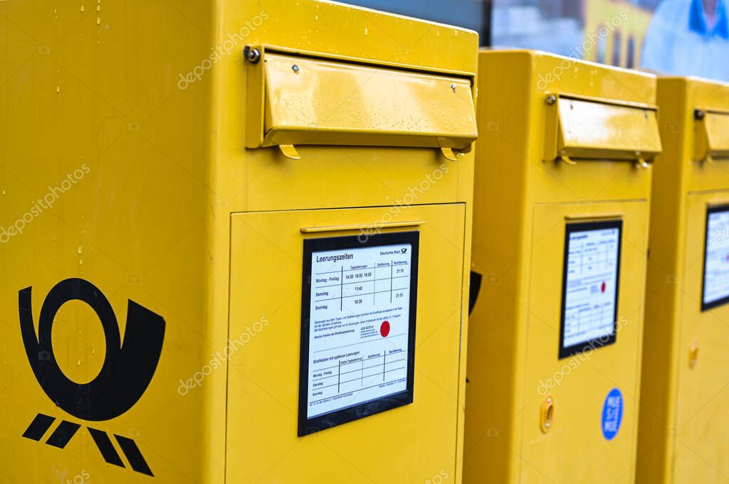 Berlin, Germany - October 5, 2019: Several mailboxes with the German Post logo in typical yellow on a sidewalk in Berlin, Germany.