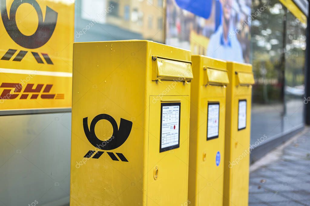 Berlin, Germany - October 5, 2019: Several mailboxes with the German Post logo in typical yellow on a sidewalk in Berlin, Germany.