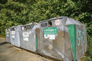 Berlin, Almanya - 19 Ağustos 2019: Yol kenarındaki bir geri dönüşüm şirketinin cam konteynırı.
