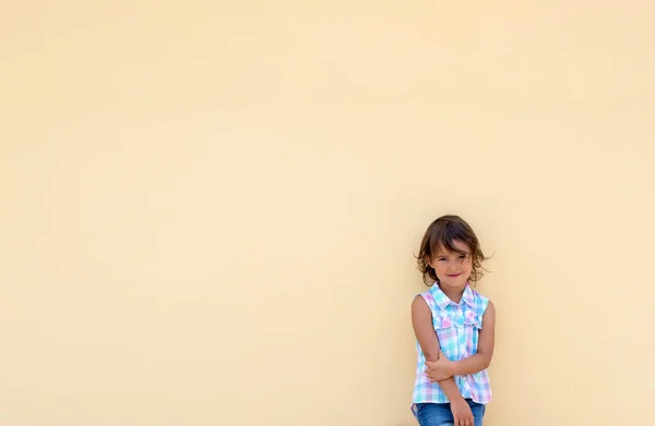 Menina Sorrindo Possuindo Lado Uma Parede Amarela — Fotografia de Stock