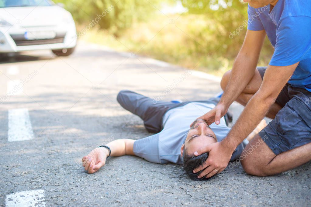 man giving first aid in car accident