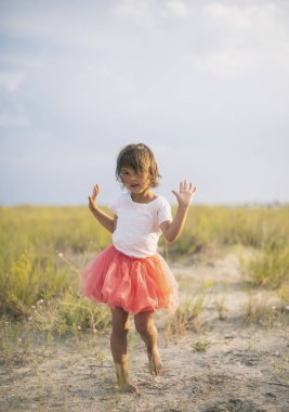 Yaz Plaj kumlu tepe üzerinde dans sevimli küçük kız