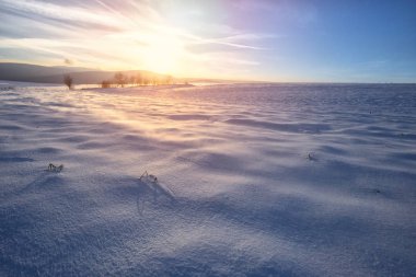 Günbatımı karla kaplı tepeler üzerinde