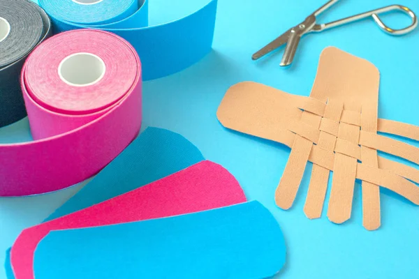 Colored kinesio tapes with a pair of scissors — Stock Photo, Image