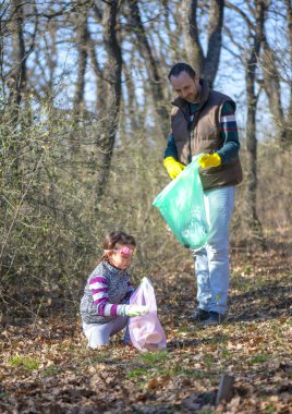 Baba ve kız parkta çöp toplama