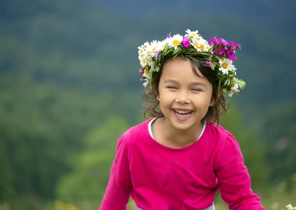 花冠の笑顔と草原で楽しんでいるかわいい女の子 — ストック写真