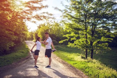 Parkta bir yolda bacaklar germe genç çift