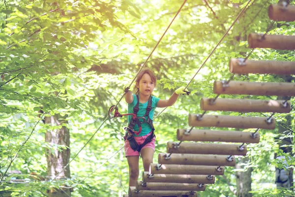 アドベンチャーパークに登る小さな女の子 少年はロープコースの冒険に登って楽しんでいます — ストック写真