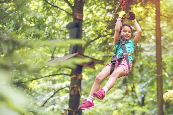木の間のジップライン上の幸せな小さな女の子 — ストック写真