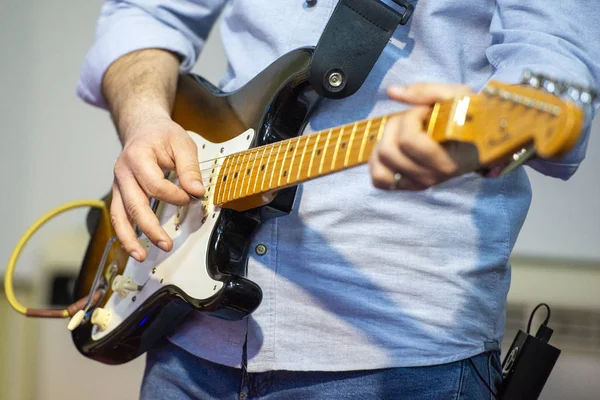 Ung man spelar på elgitarr på nära håll — Stockfoto