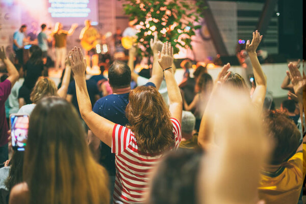 People worshiping God, with hands up.