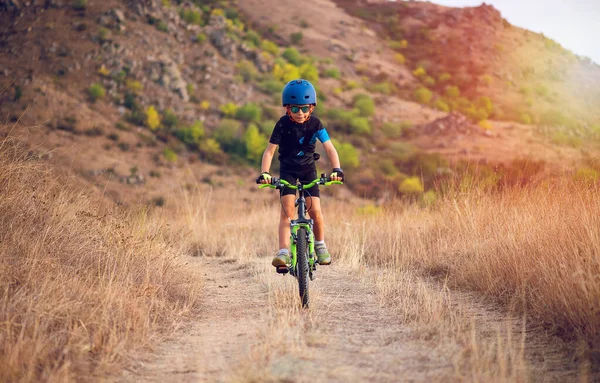 美しい秋の日に自転車で秋の公園で楽しんで7歳の幸せな子供の男の子 自転車ヘルメットを着用したアクティブな子供 — ストック写真