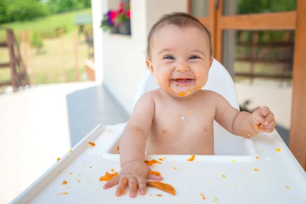 Aylık Sevimli Kirli Küçük Kız Bebek Koltuğunda Otururken Yemek Yiyor — Stok fotoğraf