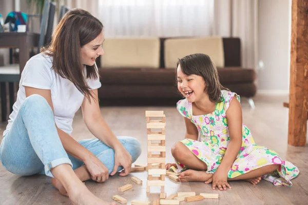 若いです母とともに彼女の小さな娘ゲームで木のブロック — ストック写真