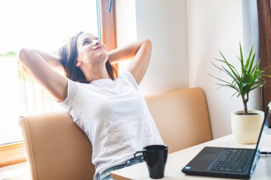 Sakin gülümseyen kadın ellerini başının arkasına koyuyor, mutlu kadın işten sonra dinleniyor, gözleri kapalı eğleniyor, stres yok.