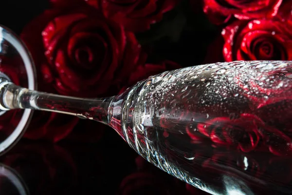 Um copo com salpicos de água e um buquê de rosas. Flores de amor Imagem De Stock