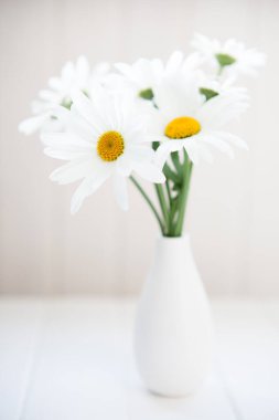 Beyaz vazoda bir buket papatya..