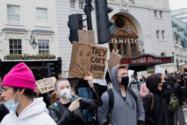 Londra, Birleşik Krallık-06-2020: Londra 'daki protestolar sırasında ırkçılığa ve polis şiddetine karşı farklı sloganları olan insanlar, maske takıyor ve Coronavirus' a karşı korunuyorlar.