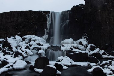 Karla kaplı volkanik siyah kayalardan akan inanılmaz şelale.