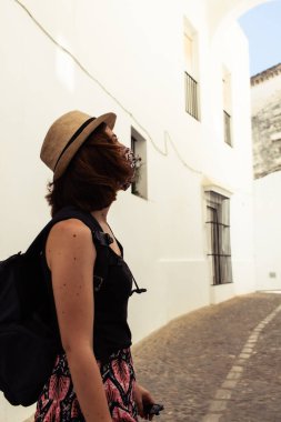 Coronavirus salgını sırasında yüz maskesi takmış yaşlı bir kasabayı ziyaret eden çekici genç bir kadın.