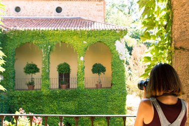 Çekici genç bir kadın, yüzü maskeli ve refleks kamerasıyla İspanya 'da eski bir manastırı ziyaret ediyor.