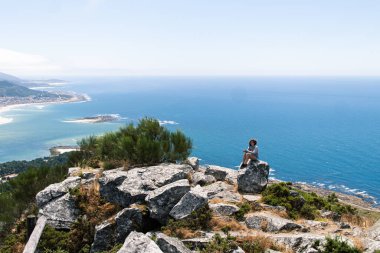 İspanya 'nın kuzeyindeki Galiçya' daki Minho nehrinin kıyılarına tanıklık eden bir kayanın tepesindeki çekici genç kadın.