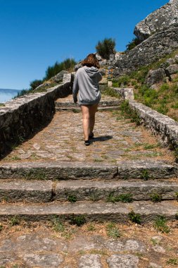 Çekici genç bir kadın, İspanya 'nın kuzeyindeki eski bir manastırın merdivenlerine tırmanıyor.