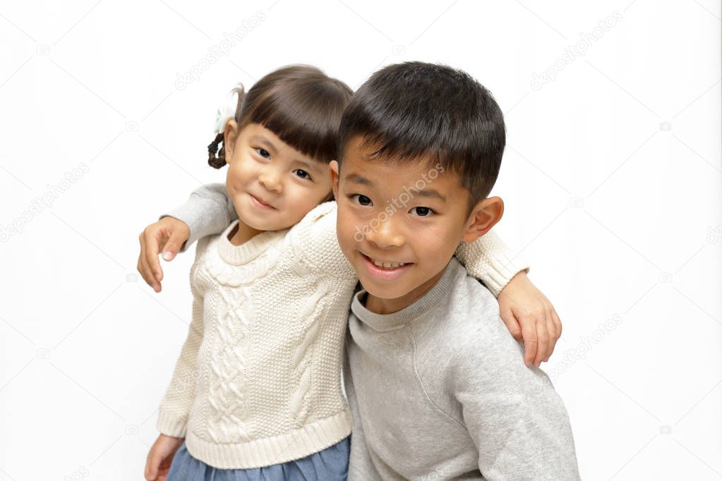 Japanese brother and sister putting arms around each other's sholders (9 years old boy and 4 years old girl)