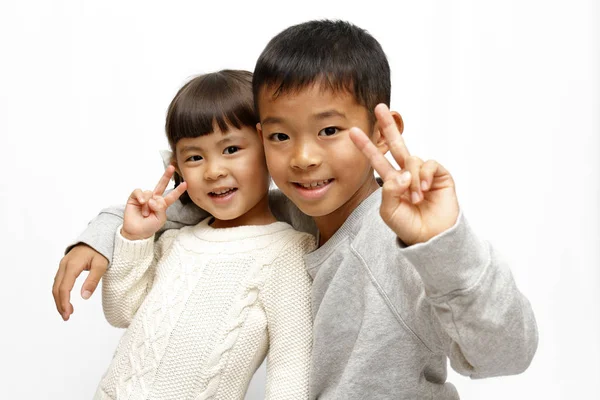 Japonês irmão e irmã colocando braços em torno de sholders uns dos outros (9 anos de idade menino e 4 anos de idade menina ) — Fotografia de Stock