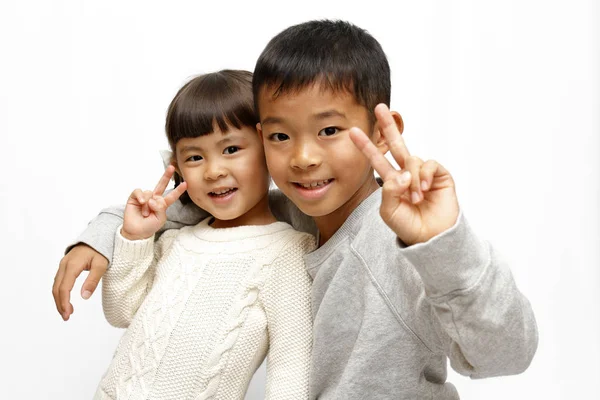 Japonés hermano y hermana poniendo brazos alrededor de la otra sholders (9 años de edad, niño y 4 años de edad, niña ) —  Fotos de Stock