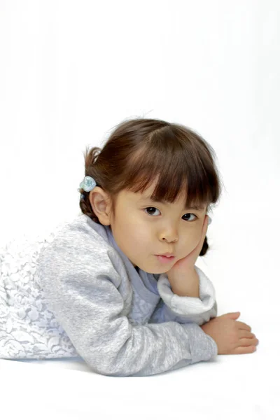 Reclining Japanese girl with resting chin in hands (4 years old) — Stock Photo, Image