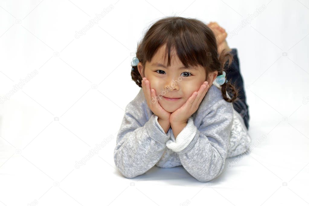 reclining Japanese girl with resting chin in hands (4 years old)