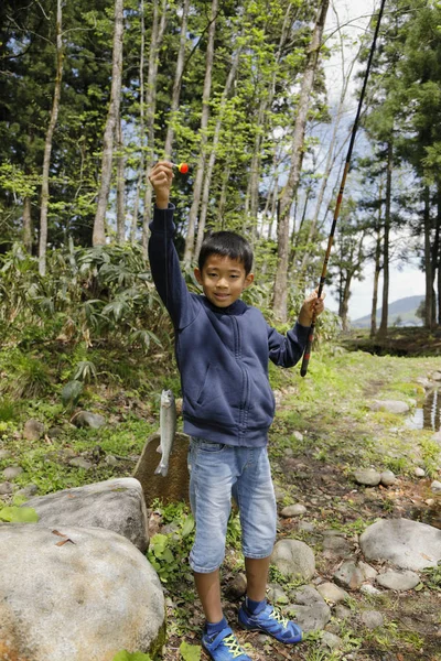 Japanese boy catching fish (fourth grade at elementary school) — Stock Photo, Image