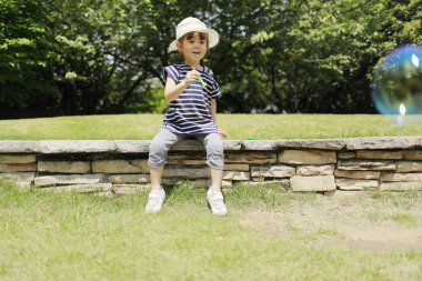 Japon kız oyun ile kabarcık altında bu mavi gökyüzü (4 yaşında)