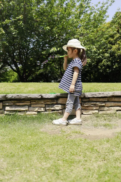 Japansk flicka leker med bubbla under den blå himlen (4 år gammal) — Stockfoto