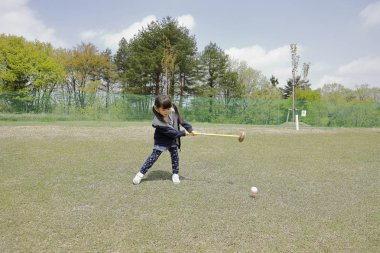 Japon kız golf koyarak oynarken (4 yaşında)