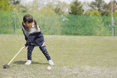 Japon kız golf koyarak oynarken (4 yaşında)