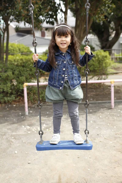 Japonesa chica en el swing (4 años de edad ) —  Fotos de Stock