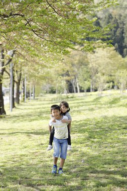 Japon oğlan taşıma onun kız kardeşi içinde onun sırt (9 yıl yaşlı oğlan ve 4 yıl eski islak gömlek)