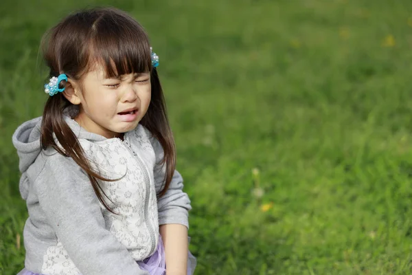 Japansk tjej gråter på gräset (4 år gammal) — Stockfoto
