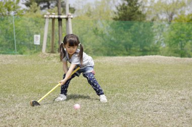 Japon kız golf koyarak oynarken (4 yaşında)