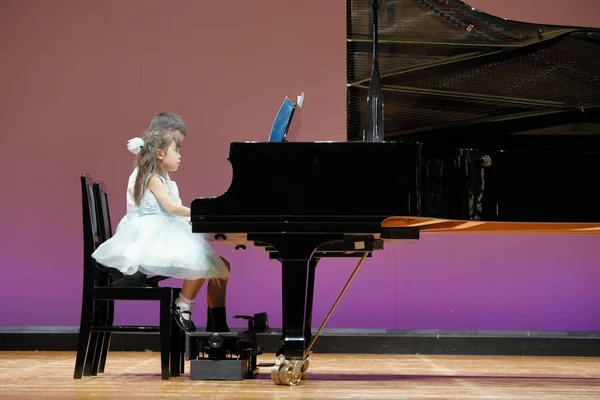 무대에서 피아노를 연주하는 일본인 남매 (9 세 소년과 4 세 소녀) — 스톡 사진