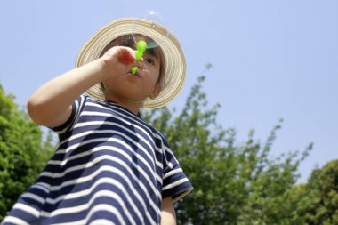 Japon kız oyun ile kabarcık altında bu mavi gökyüzü (4 yaşında)