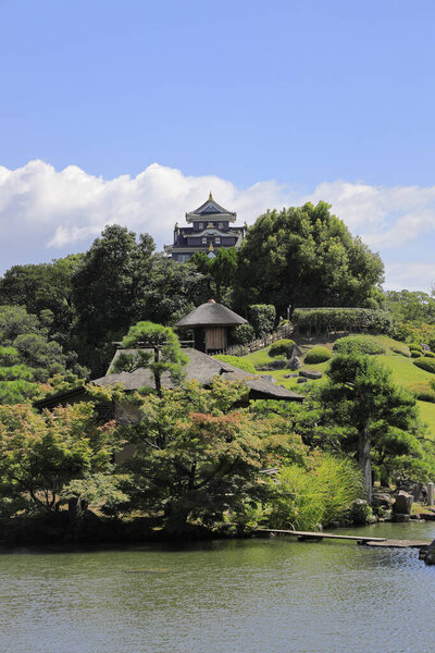 Замок Окаяма и холм Юйсиндзан в саду Кораку в Окаяме, Япония

