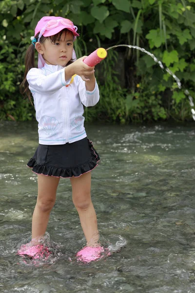 Ragazza giapponese che gioca nel fiume con pistola ad acqua (4 anni ) — Foto Stock